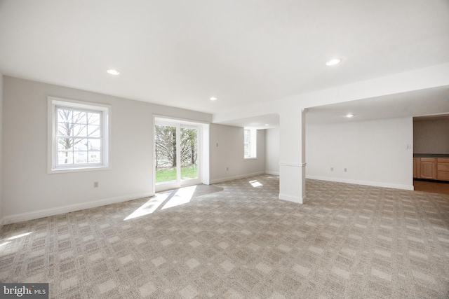 unfurnished living room featuring light colored carpet, recessed lighting, and baseboards