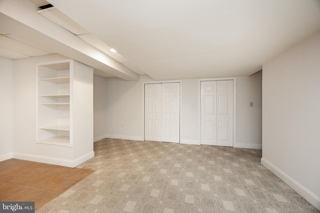 unfurnished bedroom featuring two closets, baseboards, and carpet