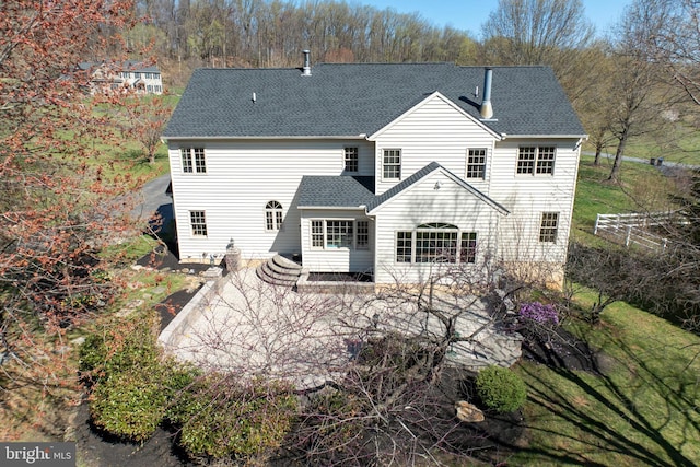 back of property with a shingled roof