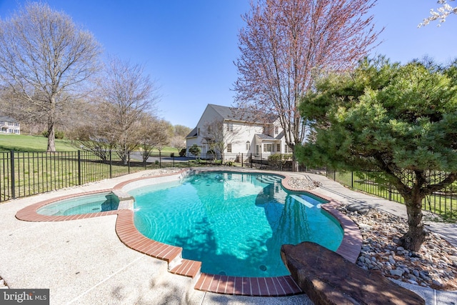 view of swimming pool featuring fence and a pool with connected hot tub