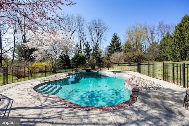 view of pool with fence, a pool with connected hot tub, and a patio area