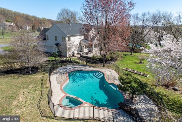 view of swimming pool with fence, a yard, a patio, and a pool with connected hot tub