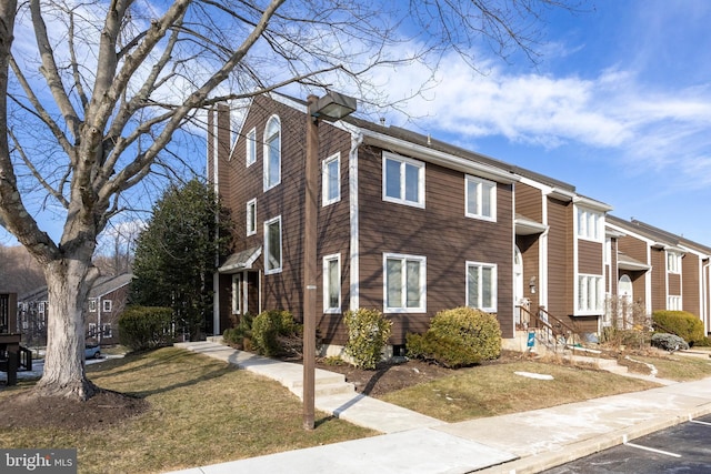 townhome / multi-family property featuring a front lawn