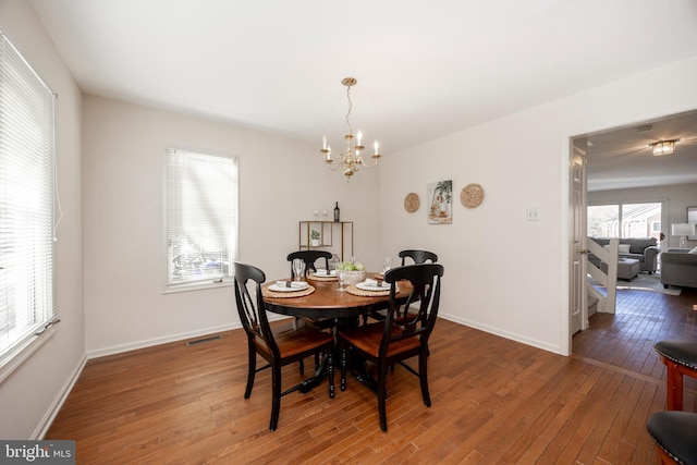 dining space with an inviting chandelier and wood-type flooring