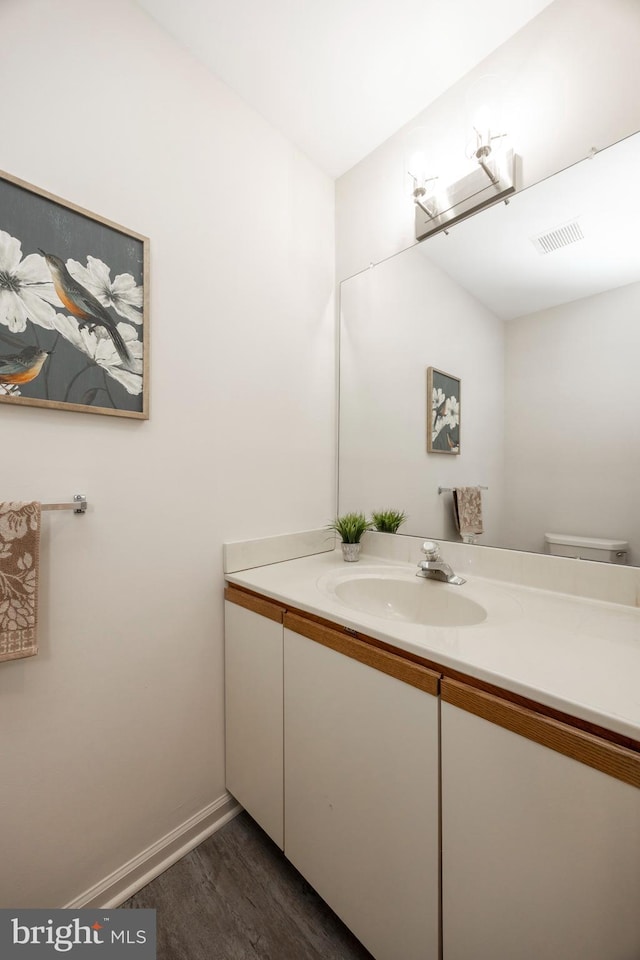 bathroom featuring vanity, toilet, and wood-type flooring