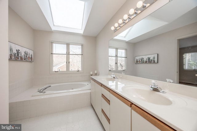 bathroom with vanity, tile patterned flooring, a relaxing tiled tub, and a skylight