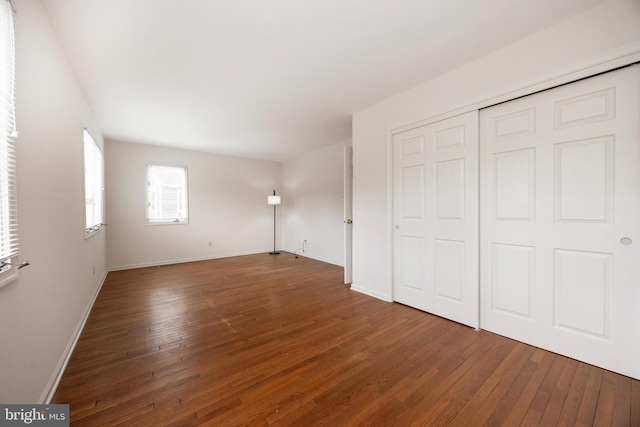 unfurnished bedroom featuring dark hardwood / wood-style flooring and a closet