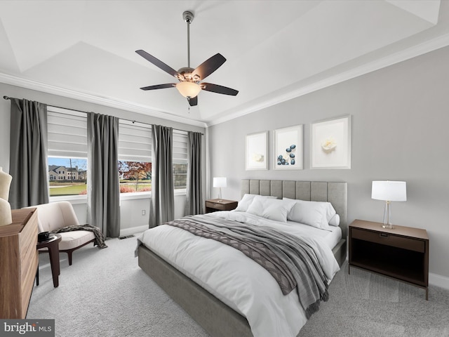 bedroom featuring a tray ceiling, ceiling fan, crown molding, and light colored carpet