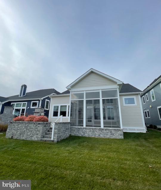 back of property featuring a lawn and a sunroom