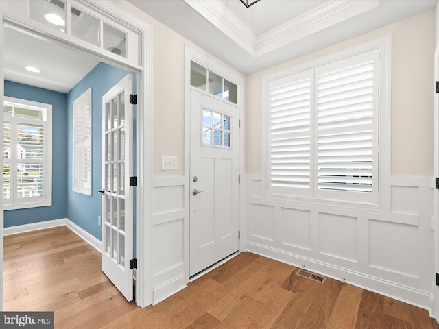 entryway with crown molding and light hardwood / wood-style flooring