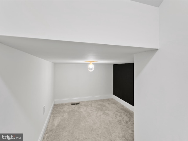 basement featuring light carpet