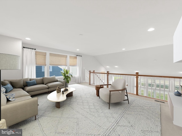 living room featuring light colored carpet and vaulted ceiling