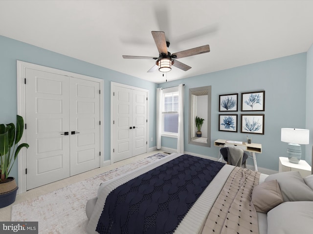 bedroom featuring light carpet, two closets, and ceiling fan