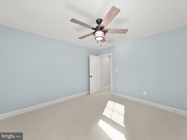 carpeted spare room featuring ceiling fan