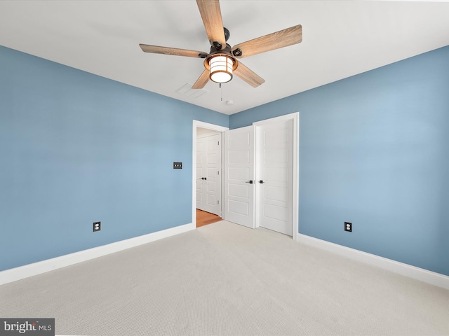 unfurnished bedroom with a closet, light colored carpet, and ceiling fan