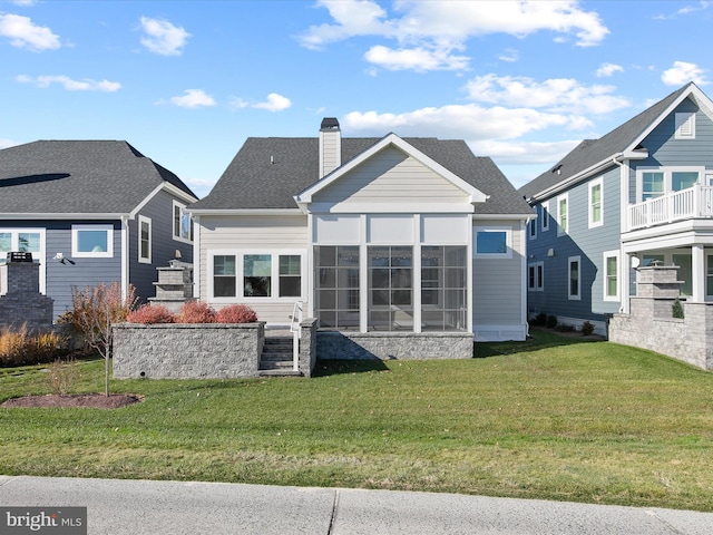 back of property with a sunroom and a yard