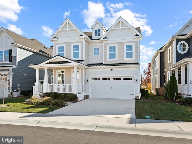 craftsman house featuring covered porch, a garage, and a front yard