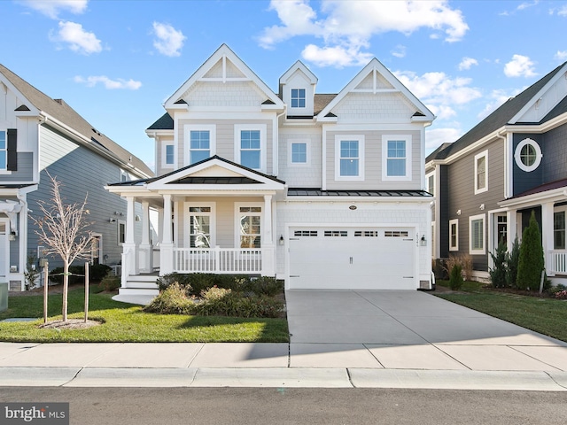 view of front of home featuring covered porch, a garage, and a front yard