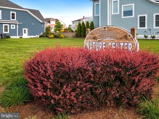 community / neighborhood sign with a yard