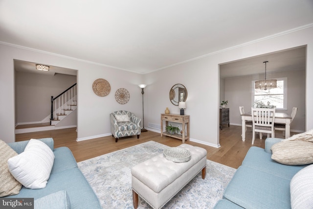 living area with stairway, ornamental molding, baseboards, and wood finished floors