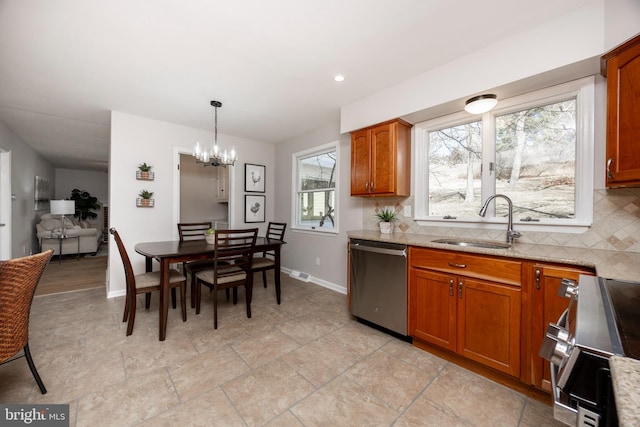 kitchen featuring brown cabinetry, backsplash, appliances with stainless steel finishes, and a sink