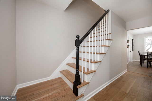 stairway with baseboards and wood finished floors