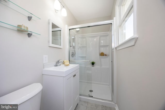 bathroom with toilet, a stall shower, and vanity