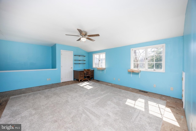 unfurnished bedroom with visible vents, lofted ceiling, carpet flooring, and a ceiling fan