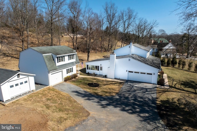 view of front of property with a gambrel roof, a front yard, roof with shingles, and driveway