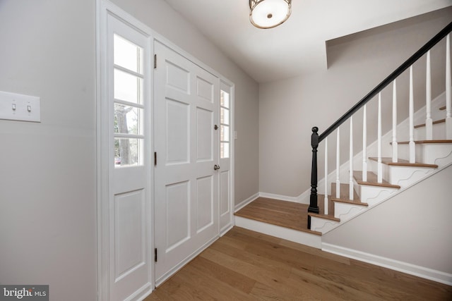 entrance foyer featuring stairs, wood finished floors, and baseboards