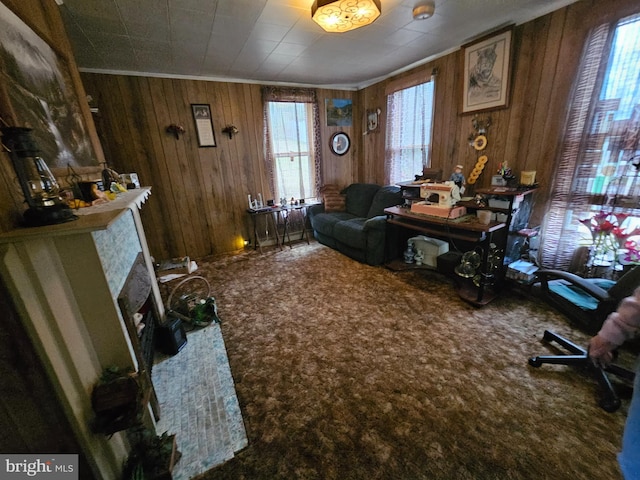 sitting room featuring carpet, crown molding, and wooden walls