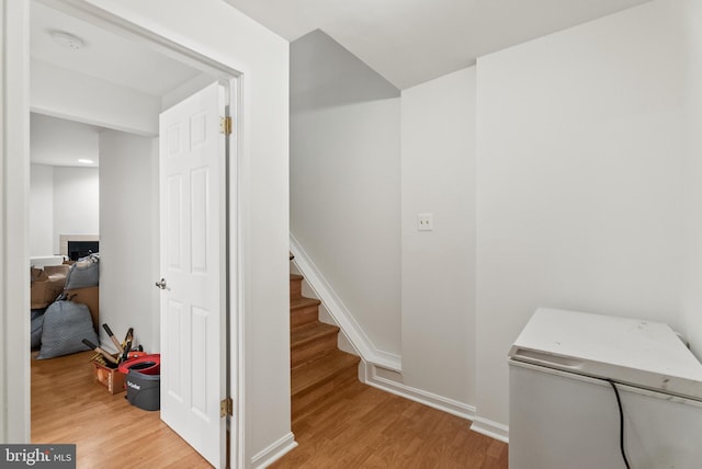 stairs with wood-type flooring and a tile fireplace