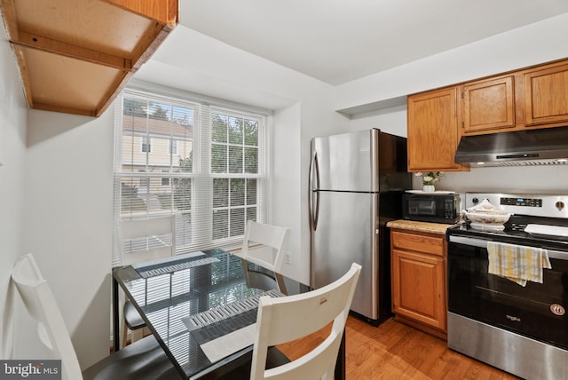 kitchen with light hardwood / wood-style floors and appliances with stainless steel finishes