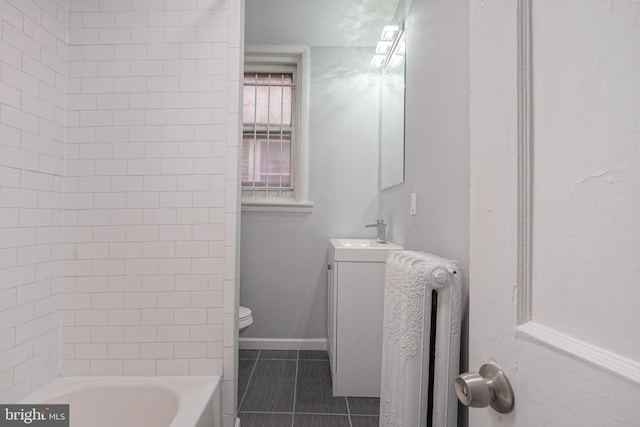 bathroom featuring toilet, vanity, tile patterned floors, and radiator