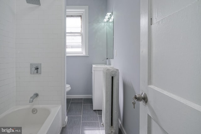 bathroom with tiled shower / bath combo and toilet