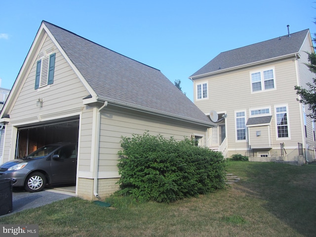 view of side of property featuring a lawn and a garage