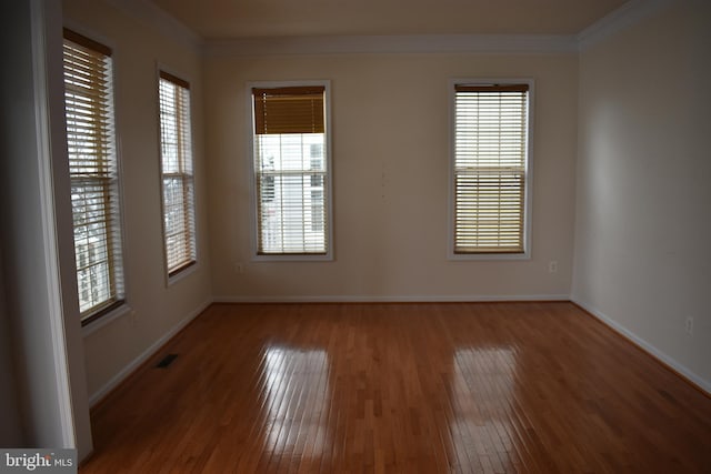 spare room with hardwood / wood-style flooring and ornamental molding