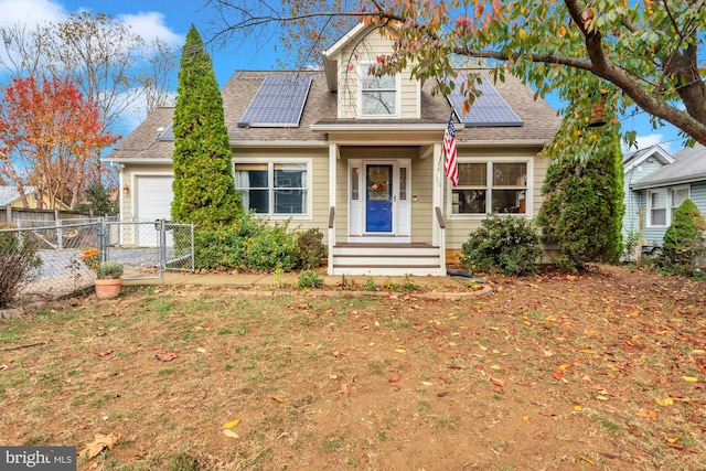 new england style home featuring solar panels and a garage