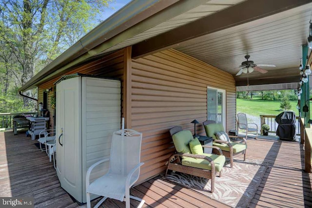 wooden deck with area for grilling and ceiling fan