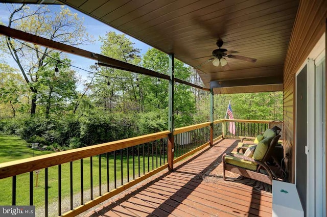 wooden deck with ceiling fan and a yard