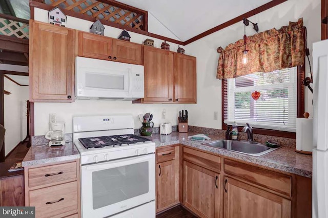 kitchen featuring lofted ceiling, sink, white appliances, and hanging light fixtures