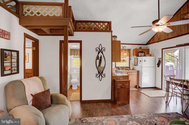 living room featuring ceiling fan, dark hardwood / wood-style flooring, sink, and vaulted ceiling