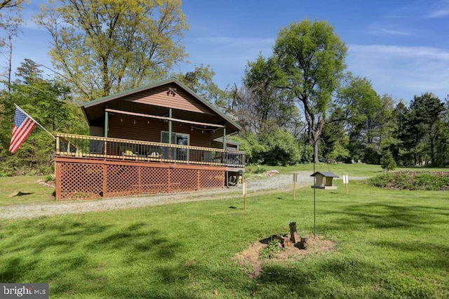 rear view of property with a wooden deck and a yard