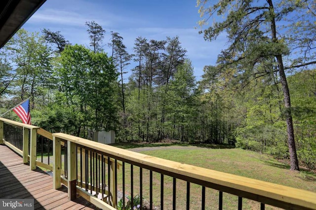 deck with a lawn and a storage shed