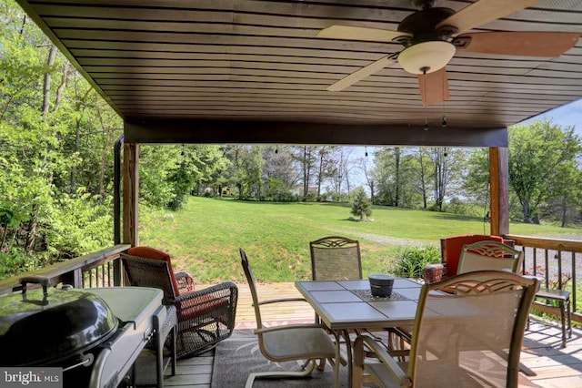 wooden deck with a yard and ceiling fan