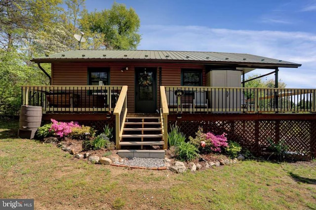 back of house featuring a wooden deck and a yard