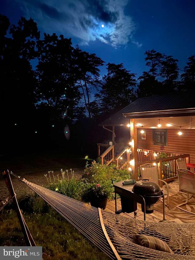 deck at night featuring an outdoor fire pit