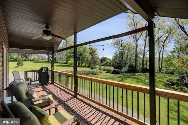 deck featuring a lawn and ceiling fan