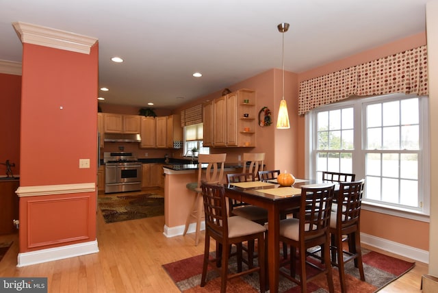 dining area with light hardwood / wood-style floors and crown molding