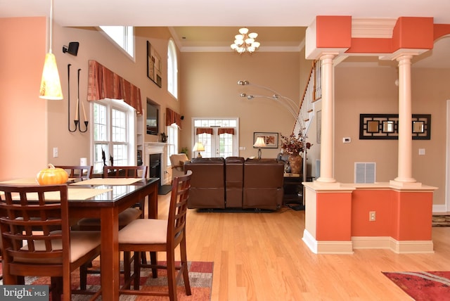 dining area featuring a high ceiling, light hardwood / wood-style floors, french doors, and ornamental molding